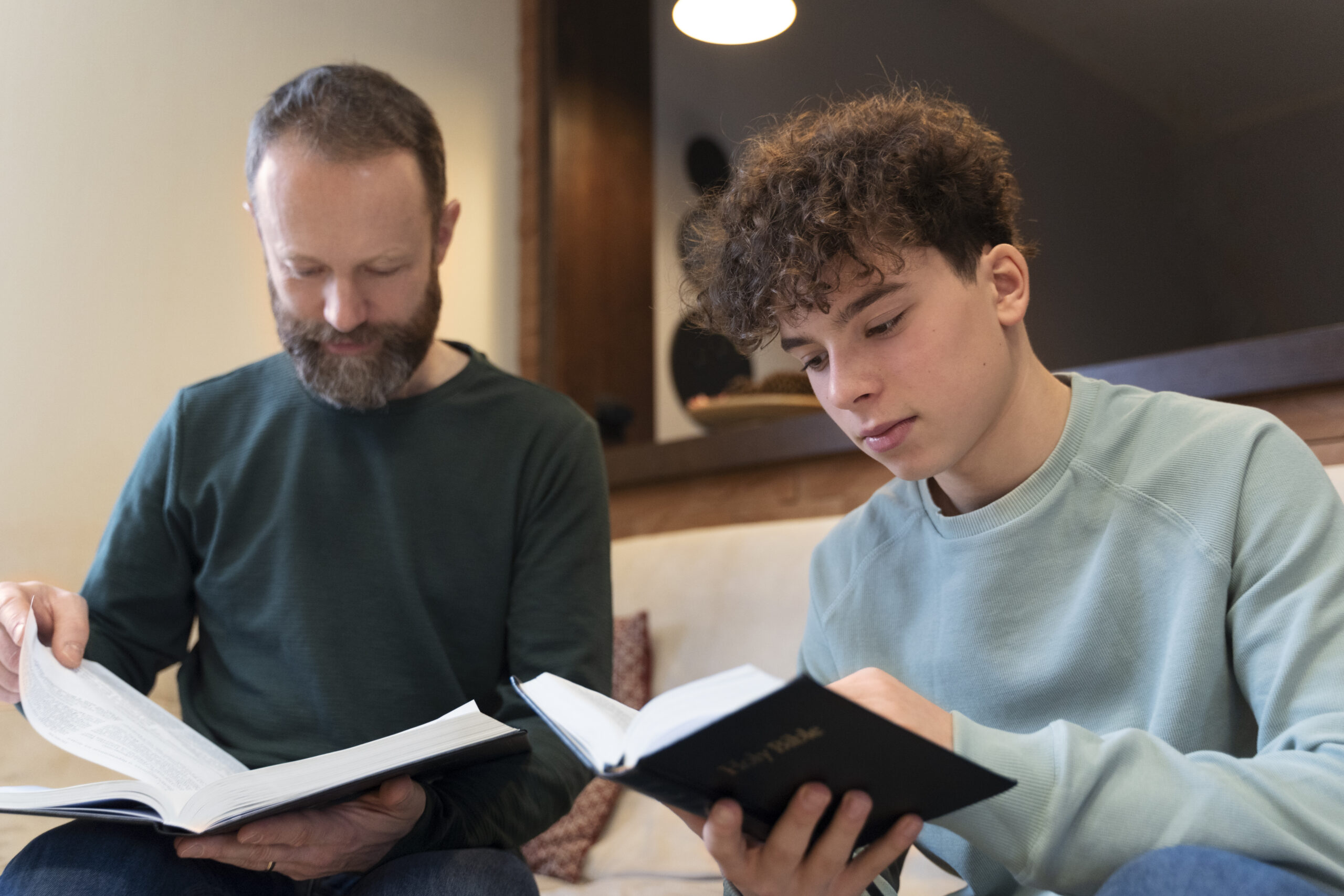 Father and son reading Bible together.
